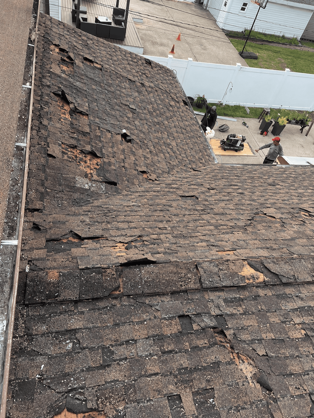 Bluemaster Roofing crew finishing a brown architectural shingle roof replacement with ridge vent on a Nassau County home near Lynbrook